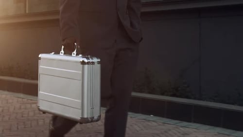 Businessman Walking with Briefcase in City at Sunset