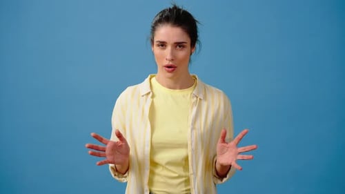 Woman Gesturing and Displaying Emotions on Blue Background