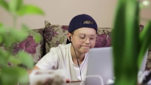Junger Gamerboy mit Kopfhörern, der zu Hause Musik genießt.