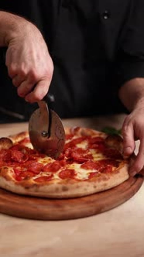 Cutting Fresh Pepperoni Pizza With Pizza Cutter
