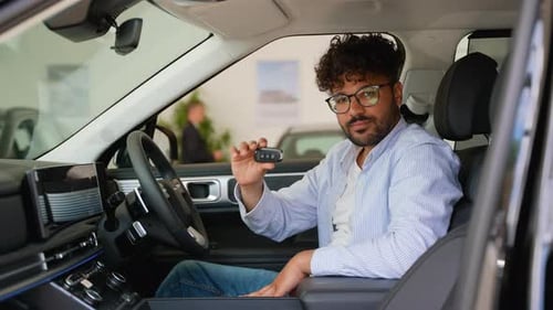 Happy Customer Showing New Car Key Inside Dealership