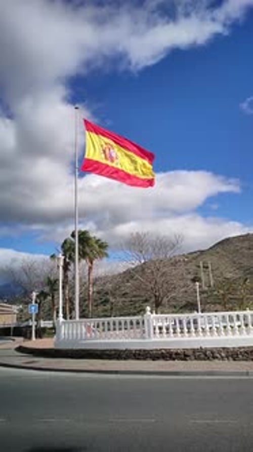 Spanish Flag Waving Proudly in a Town Square
