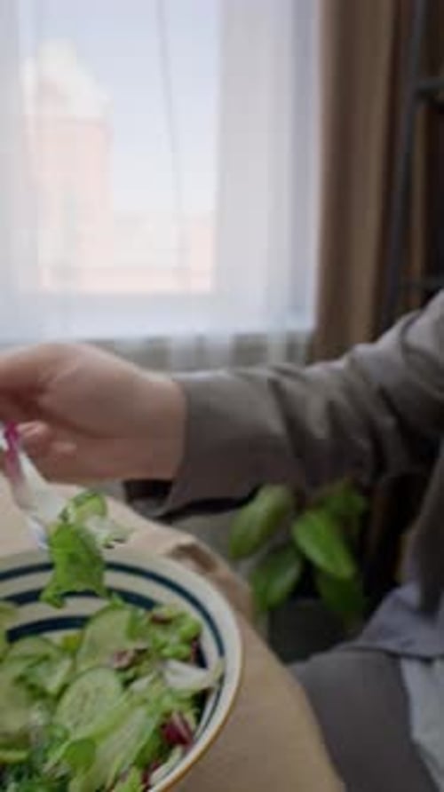 Young Man Leading Healthy Lifestyle Eating Fresh Green Salad at Home