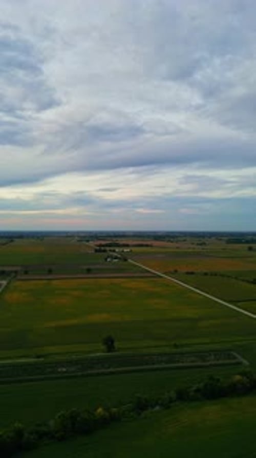 Luftaufnahme von ausgedehntem Ackerland und Landstraßen bei Sonnenuntergang