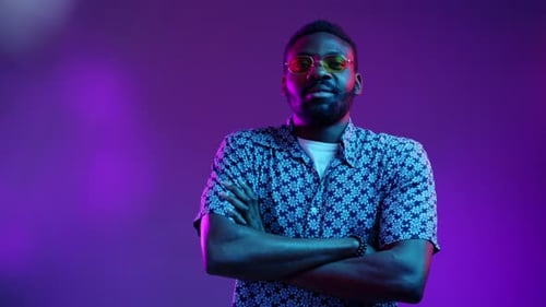Stylish Man Smiling in Studio with Colorful Lights