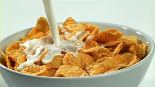 Milk Being Poured on Corn Flakes Cereal