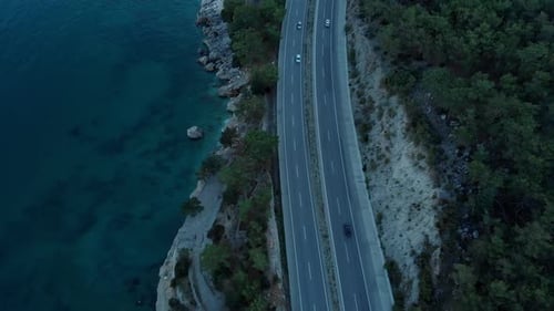 The Camera Flies Over the Road Located on the Seashore in the Evening