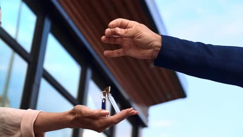Male Real Estate Seller Hand Toss Keys From Countryside House to Female Buyer Closeup Slowmo