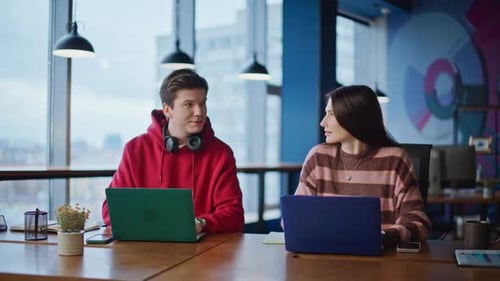 Colleagues Working on Laptops in a Modern Office