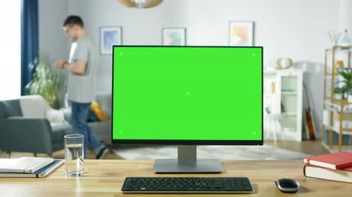 Modern Personal Computer with Green Mock-up Screen Display Standing on the Desk in the Cozy Living