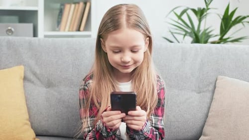 Smiling Girl Holding Mobile Phone Indoors