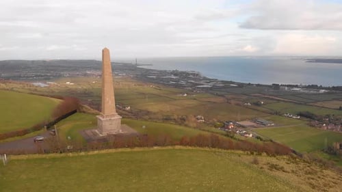 Orbiting point of interest aerial drone shot of Knockagh World War Monument during sunset revealing