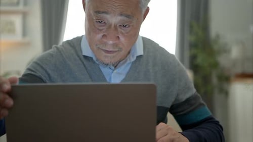 Senior Man Using Laptop at Home Close Up