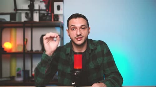 Modern Podcaster Speaking to Camera in Bright Studio Environment with HighQuality Microphone