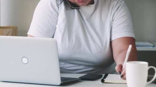 Woman Working at Desk on Laptop While on Phones