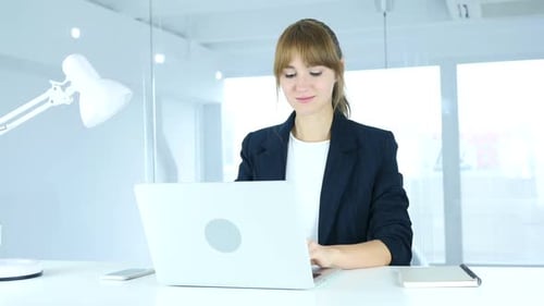 Young Female Working On Laptop in Office