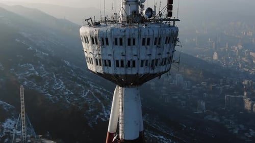 Aerial View of a Communication Tower Overlooking a Hazy Cityscape