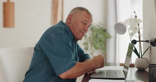 Senior Man Working at a Desk with a Laptop