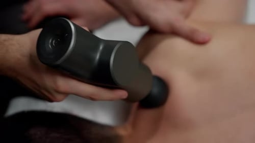 Massage Gun Used on Man's Upper Back