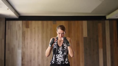 Focused Woman in Boxing Stance with Fists