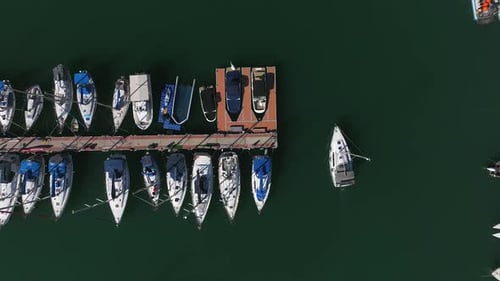 Luftbild eines kleinen Segelbootes, das langsam einen Yachthafen verlässt