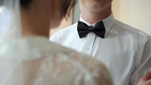Bride Adjusts Groom's Bowtie in Preparation for Wedding