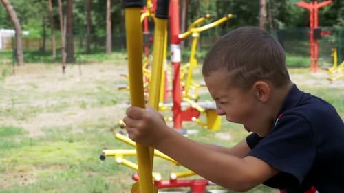 Child Boy Engaged on Sports Training Simulator at the Street in Slow Motion