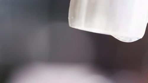 Nahaufnahme eines laufenden tropfenden Wasserhahns. Fließendes und sprudelndes Wasser. Silberne Küchenarmaturen aus Leitungswasser,