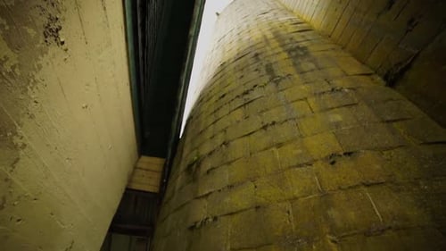Slow pan down of the outside rustic abandoned barn silo on the grounds of an insane asylum, chipped