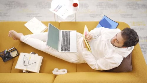 Man Working from Home on Couch with Laptop