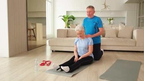 Older Couple Exercising and Massaging at Home