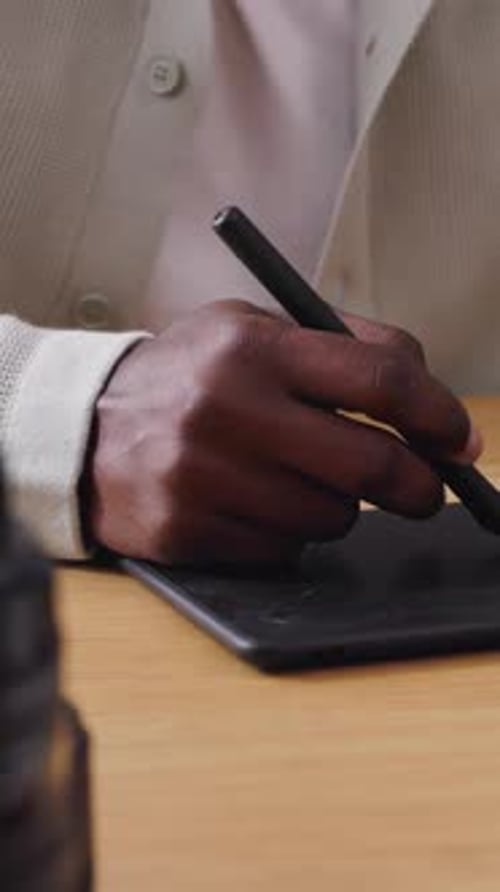 Fotógrafo editando fotos com caneta Stylus e tablet em seu espaço de trabalho brilhante