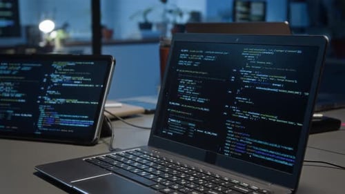 Código de programação exibido no laptop conectado ao tablet digital na mesa cinza