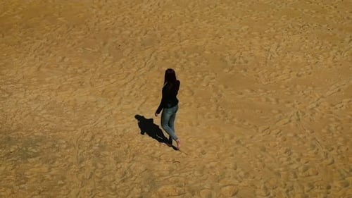 Woman Walking Barefoot on Sandy Beach from Above