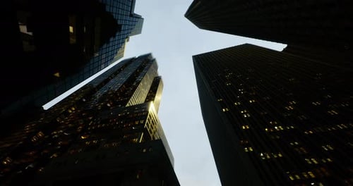 View of Towering Skyscrapers and City Skyline at Dusk with Illuminated Windows