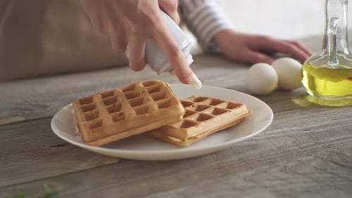 Adding Whipped Cream To Fresh Waffles for Breakfast