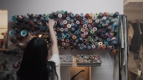 Der Modedesigner wählt die Farbe der Fäden