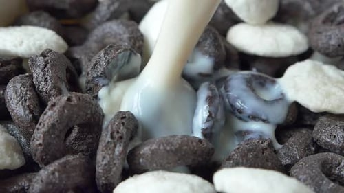 Milk is Poured over Chocolate and White Cereal