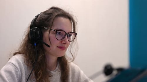 Woman with Headset Working at Computer