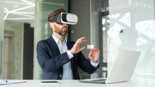 Successful businessman works using VR glasses in virtual reality simulator sitting at workplace
