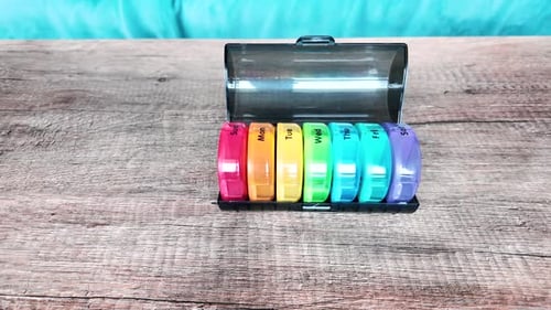 Boîte colorée en plastique pour consommer des pilules tous les jours. Vue de gauche à droite.