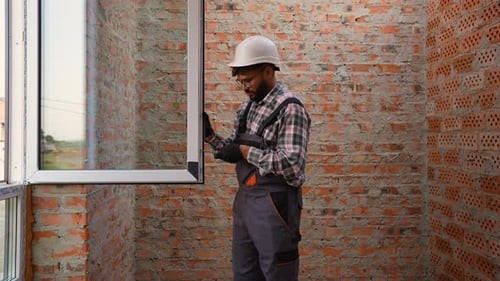 Construction Worker Inspecting a Window Installation