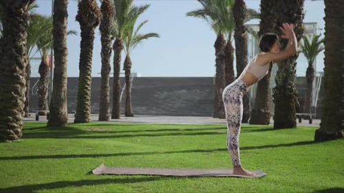 девушка делает позу дерева в парке