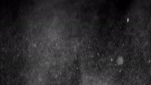 Dust falling on black background close-up