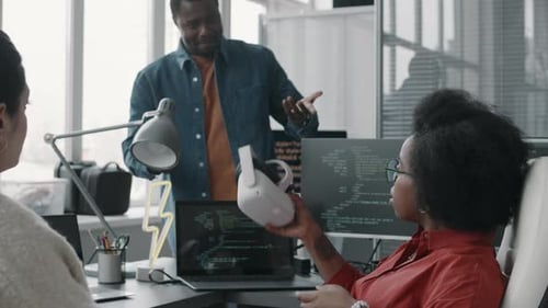 Multiethnic Team of Office Colleagues Using VR Headset at Workplace
