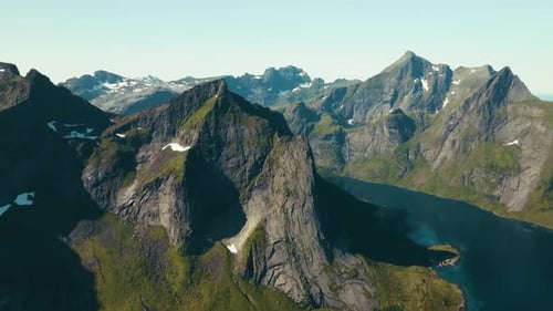 Drone-captured footage over the dramatic mountain peaks of Lofoten, Norway. The scene highlights
