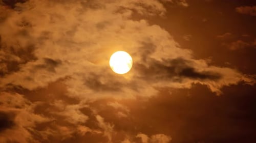Golden Sun Behind Moving Clouds at Sunset