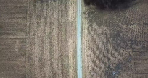 Aerial top down view of lonely desolated road through plowed land in countryside