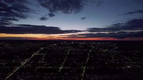 Aerial View of the Panorama of City Blocks in Lights and Roads with Traffic on the Background of a