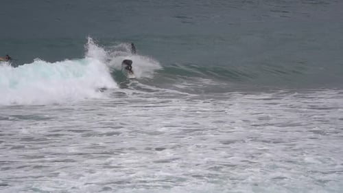 Surfer ride waves in slow motion at Las Canteras beach in Las Palmas de Gran Canaria, Spain.